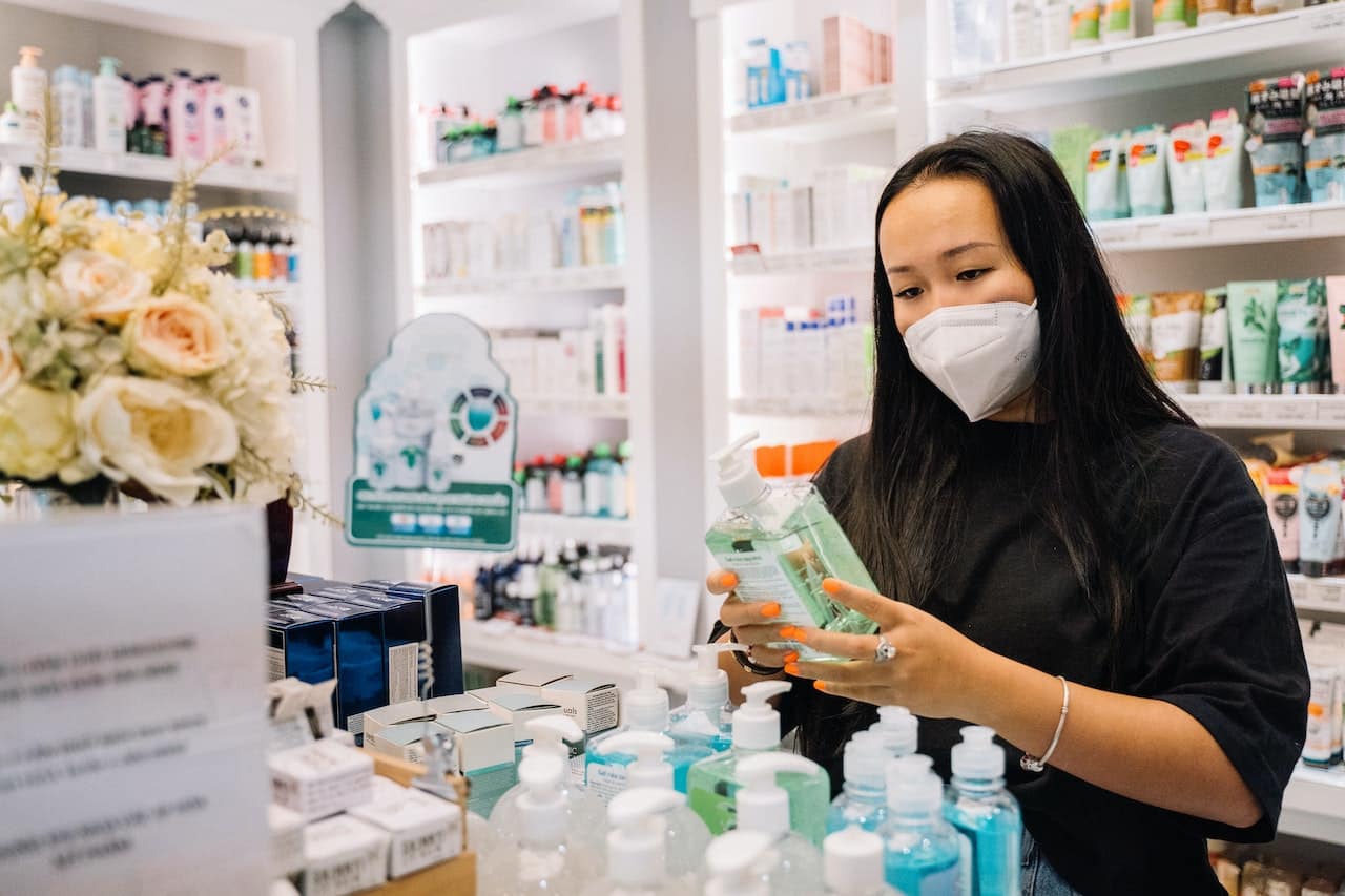 A woman holding a hand sanitizer bottle