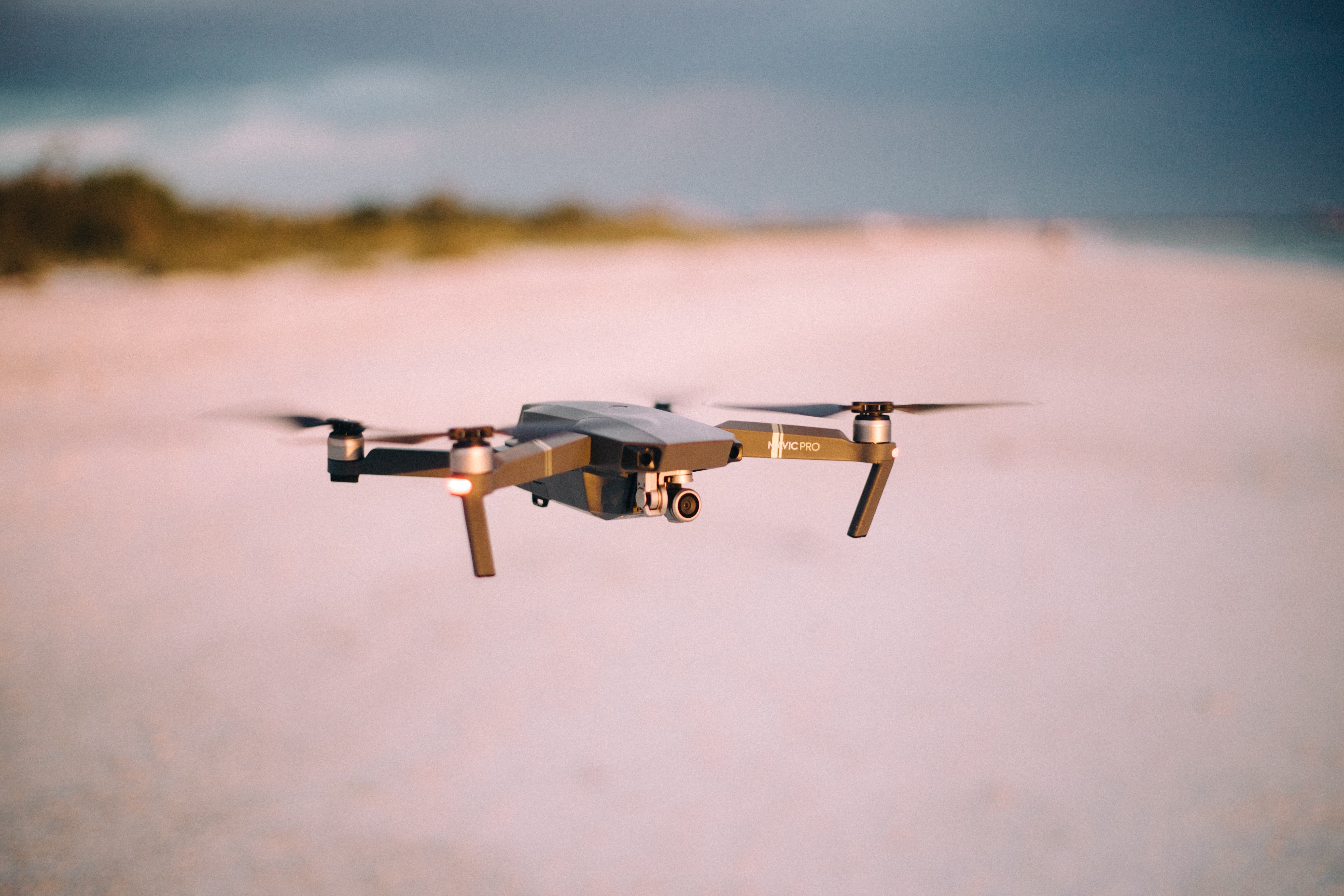 A drone hovers above a beach