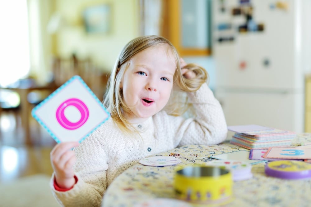 kindergarten esl student holding a flashcard