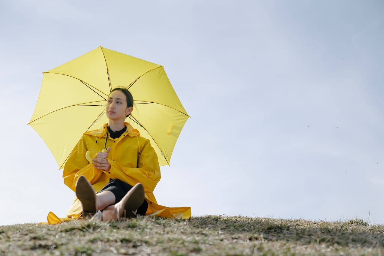 A woman with a raincoat and an umbrella