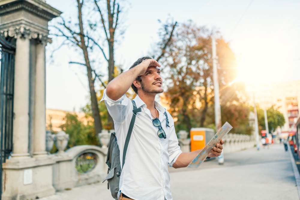 Young guy traveling around and looking at a map